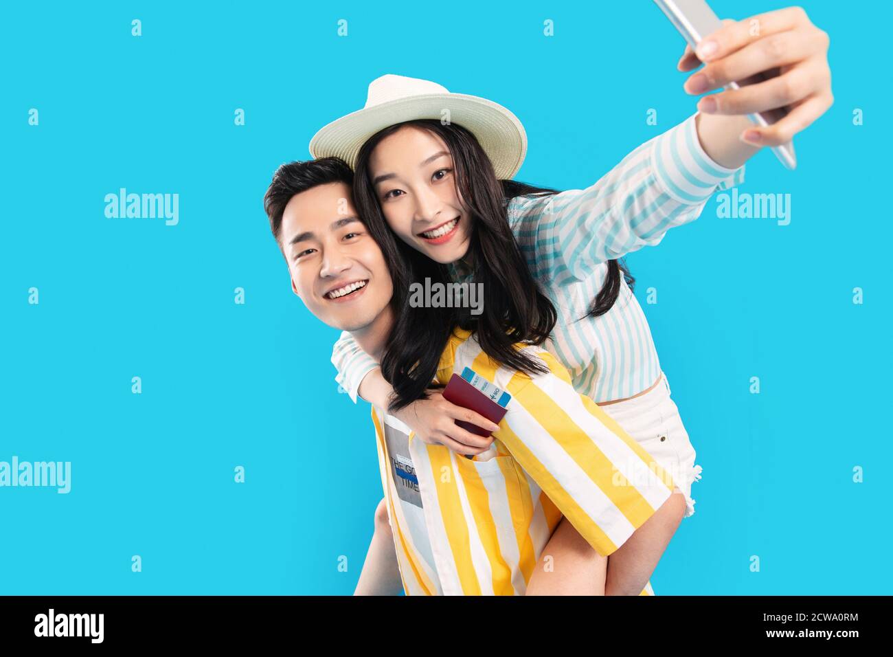 Young man carrying a girlfriend using a mobile phone Stock Photo