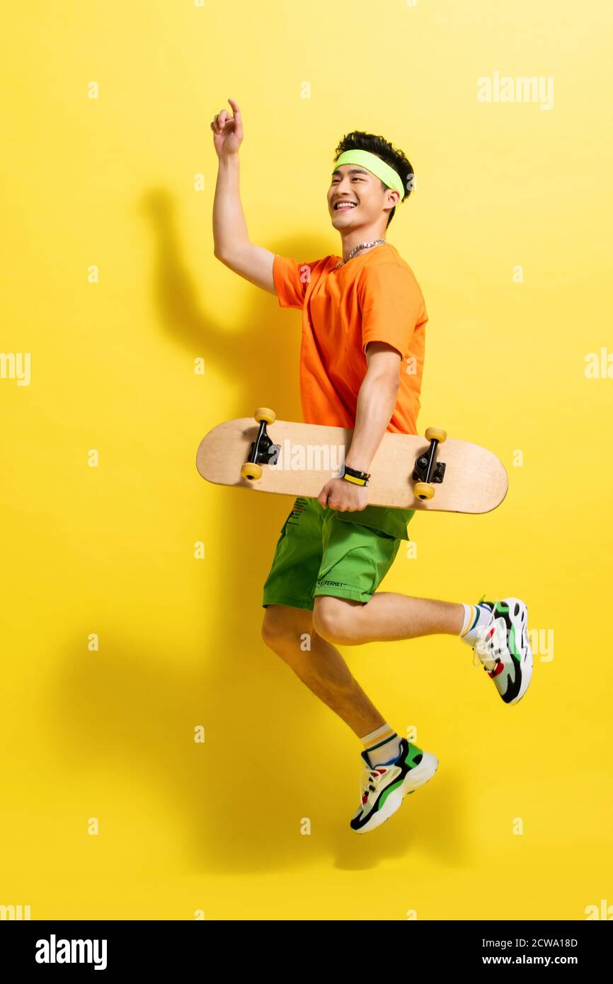 With a skateboard bouncing dynamic young man Stock Photo