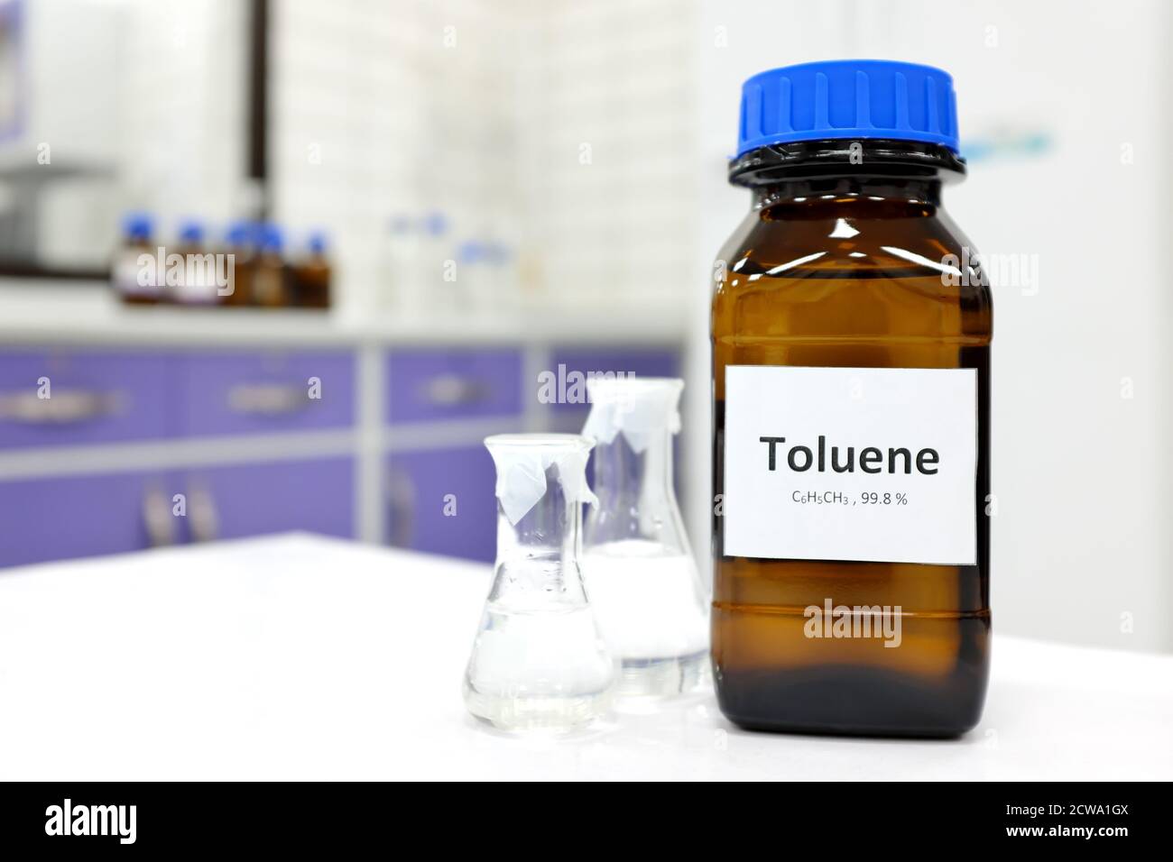 Selective focus of toluene liquid chemical compound in dark glass bottle inside a chemistry laboratory with copy space. Aromatic hydrocarbon used in petrochemical industry. Stock Photo