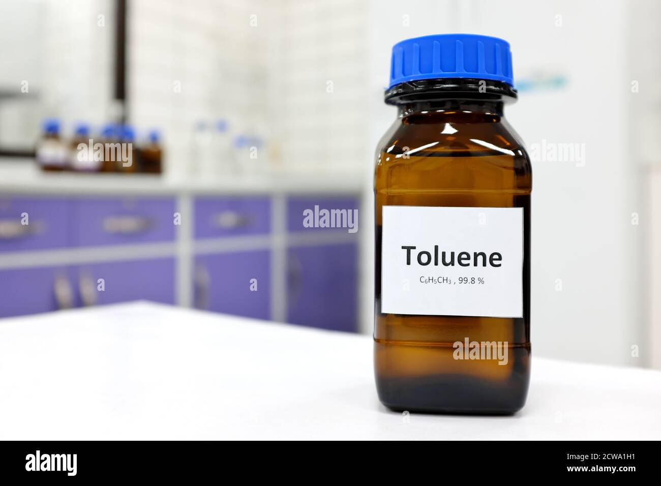 Selective focus of toluene liquid chemical compound in dark glass bottle inside a chemistry laboratory with copy space. Aromatic hydrocarbon used in petrochemical industry. Stock Photo