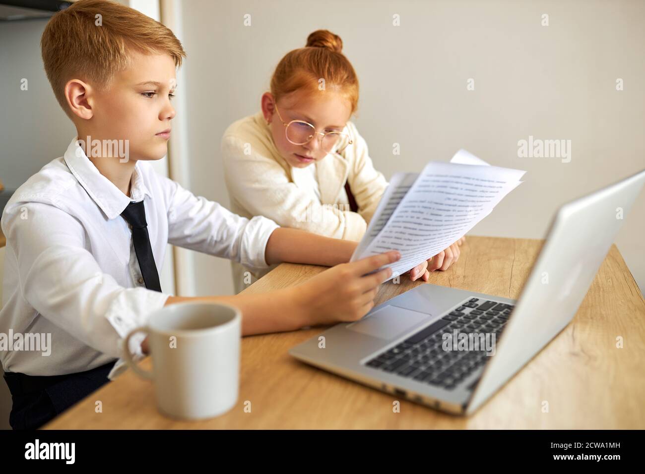 beautiful caucasian couple children work on laptop together, solve family problems, pay bills online, have talk. at home, they behave themselves as adults Stock Photo