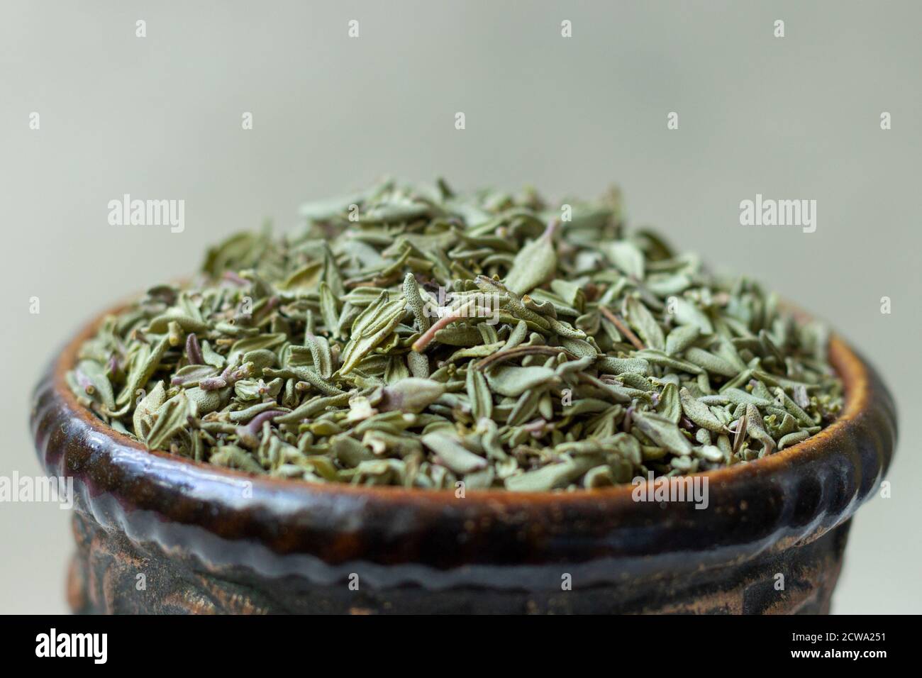 Dried thyme (Thymus) in a earthenware bowl. Stock Photo