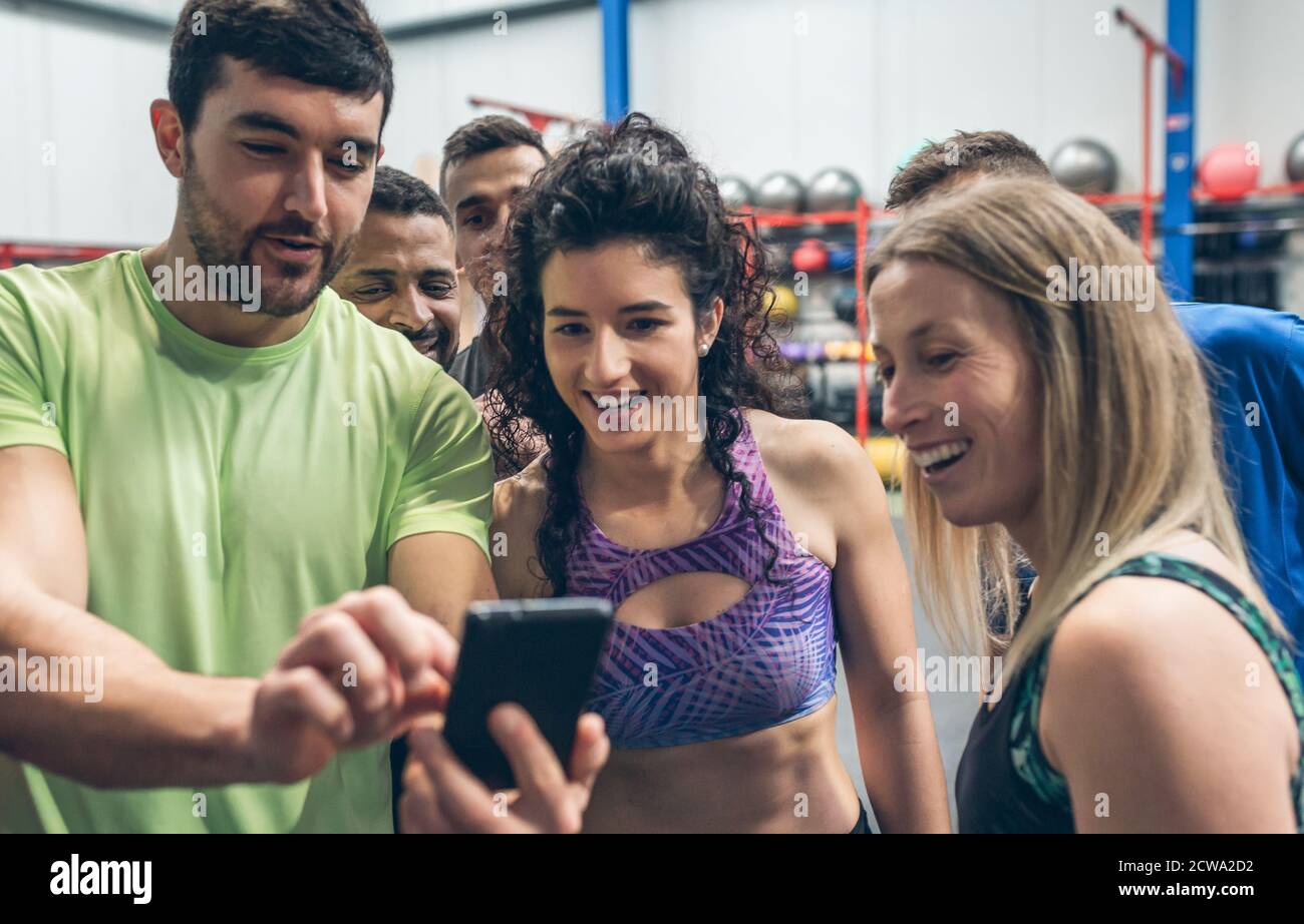 Athletes looking at the mobile of a gym mate Stock Photo