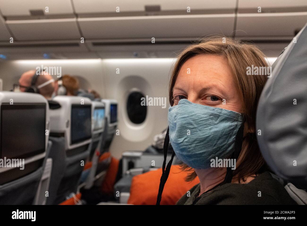Passenger on a plane wearing a mask during the Covid pandemic Stock
