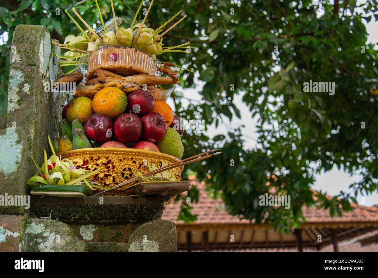 A colourful Balinese offering consist of fruits and cake that presented during a temple ceremony in Bali Indonesia Stock Photo