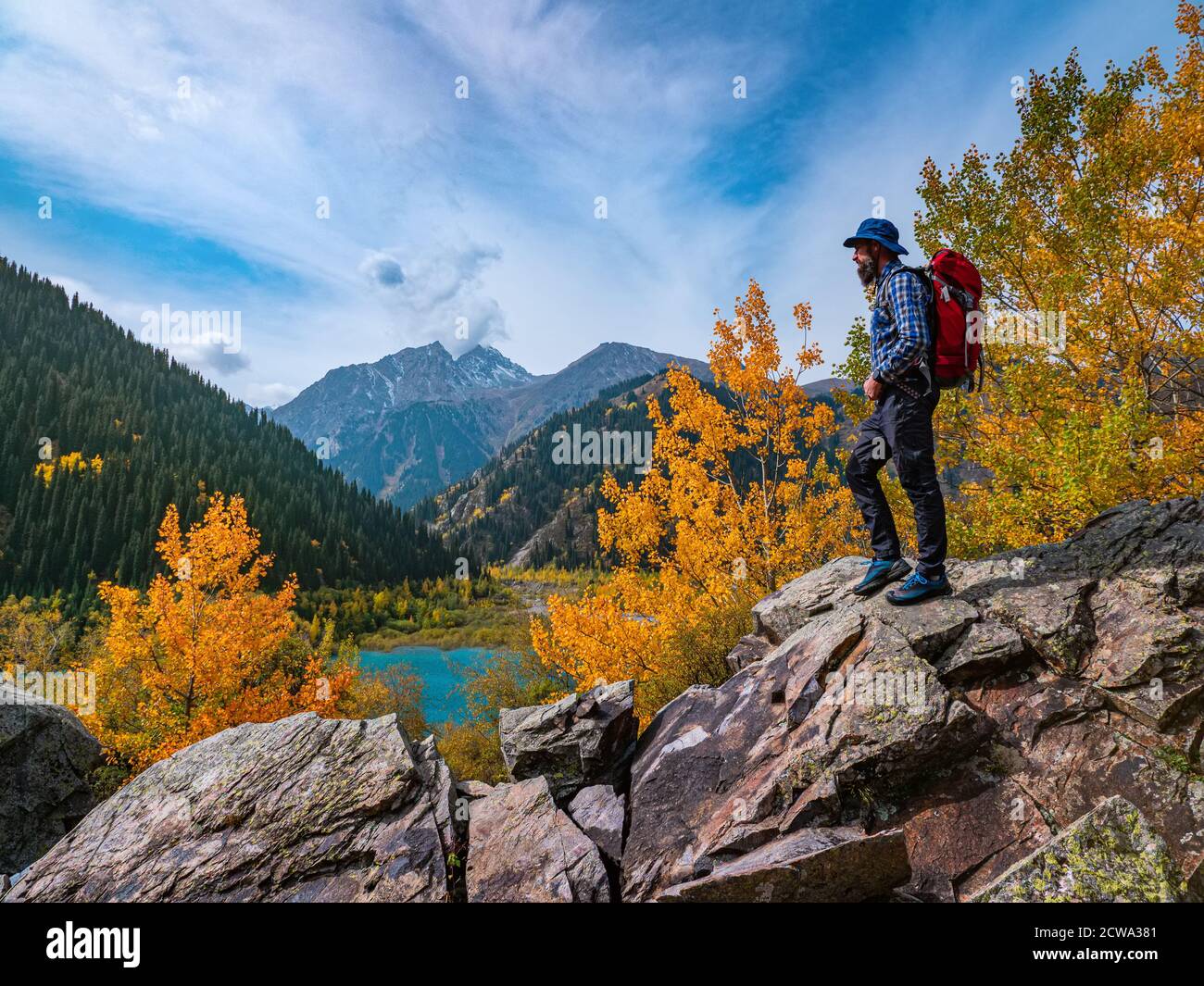Man outdoors in the mountains. Autumn on the Issyk mountain lake Stock Photo
