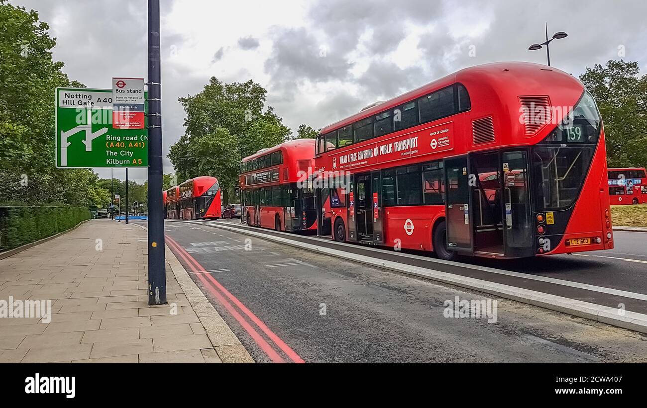 London, UK - July 8, 2020: Modern red double-decker buses waiting for people in central London by Notting Hill Gate bus stand. It says on the bus - We Stock Photo