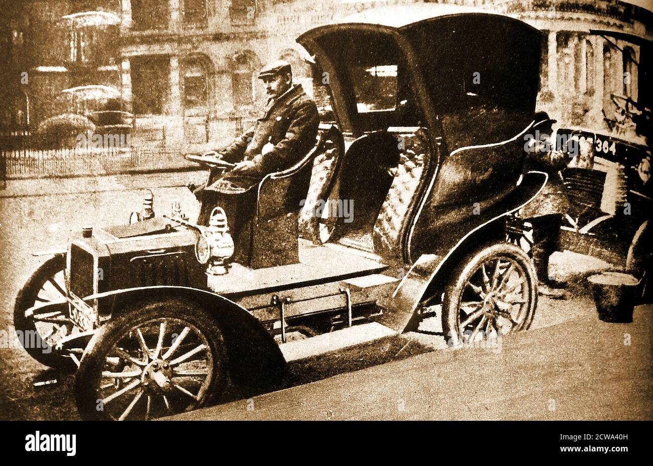 1904 photograph of London's very first motorised taxi cab using a Hansom Cab body on wheels, owned by the City & Suburban Cab Co.The first petrol powered cab in London  (in 1903) was a French-built Prunel.  British makes included a few Rational, Simplex and Herald vehicles. Earlier ‘Hummingbirds’  (electric powered vehicles) nicknamed from the sound that they made  were introduced in 1897 Stock Photo