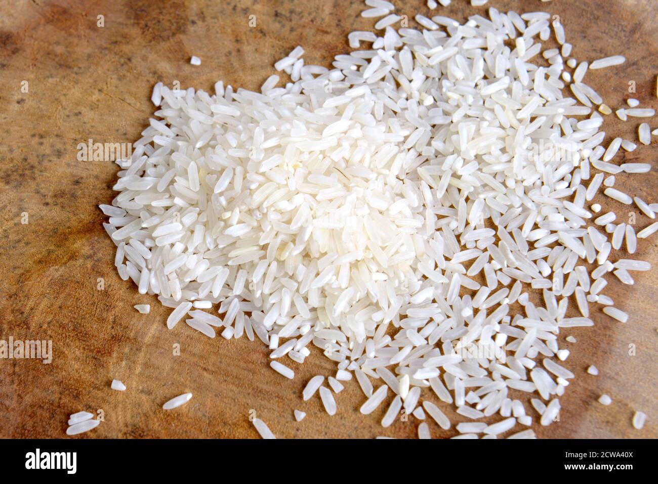 Close up view of uncooked rice with wooden background Stock Photo - Alamy