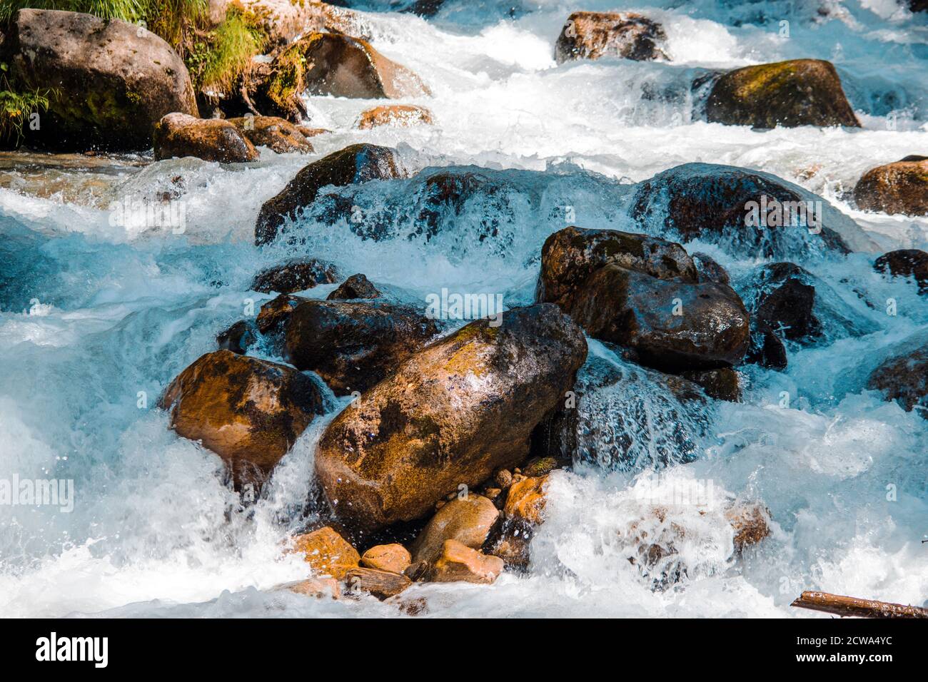 the water of a stormy mountain river flowing among stones and boulders ...