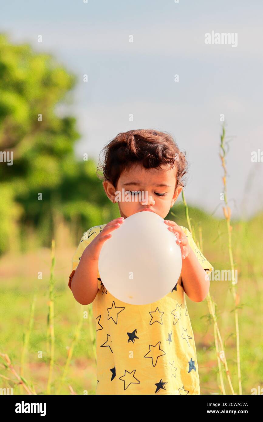 portrait An Indian boy pours air into the balloon Stock Photo