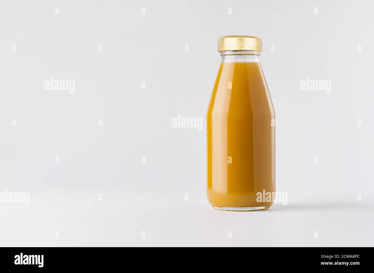 Orange mango juice in glass bottle with gold cap mock up on white