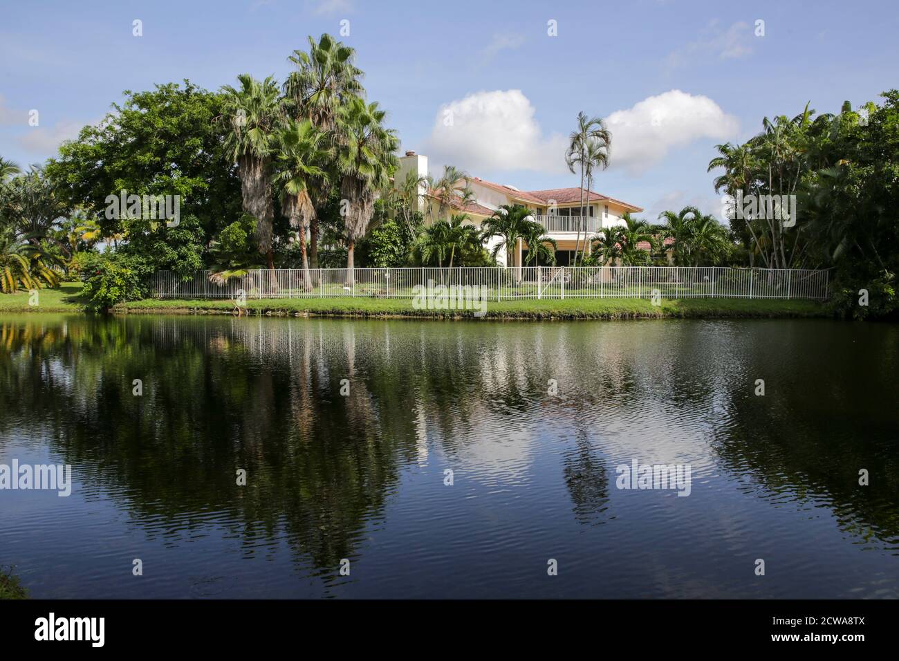 Houses, trees and sky reflecting in a pond in a park in Fort Lauderdale, Florida, USA Stock Photo