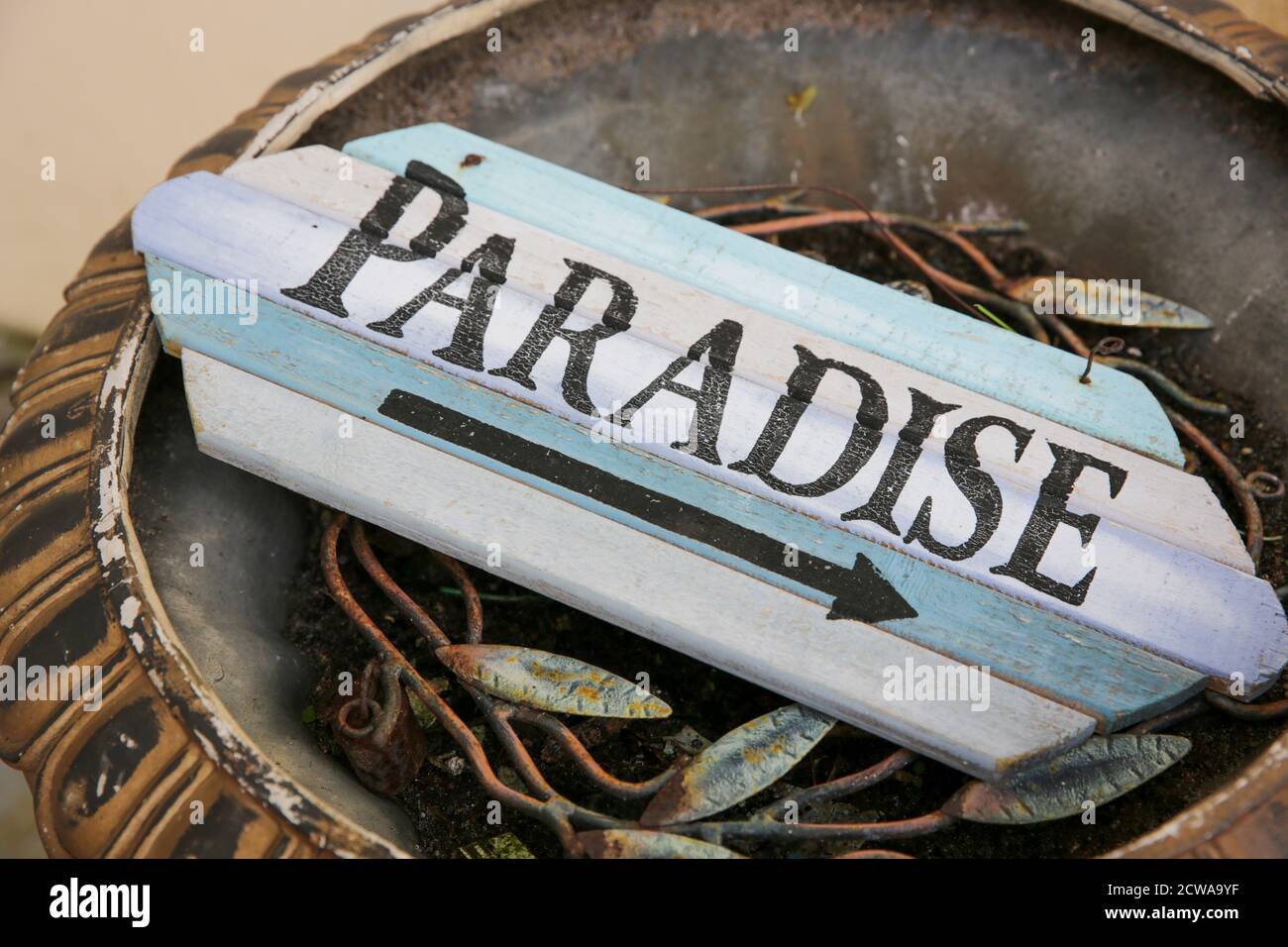 weathered wooden sign with an arrow pointing right to paradise Stock Photo
