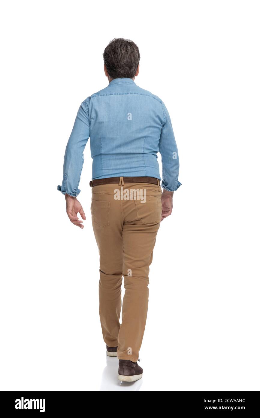 Rear view of a confident casual man walking forward on white studio  background Stock Photo - Alamy