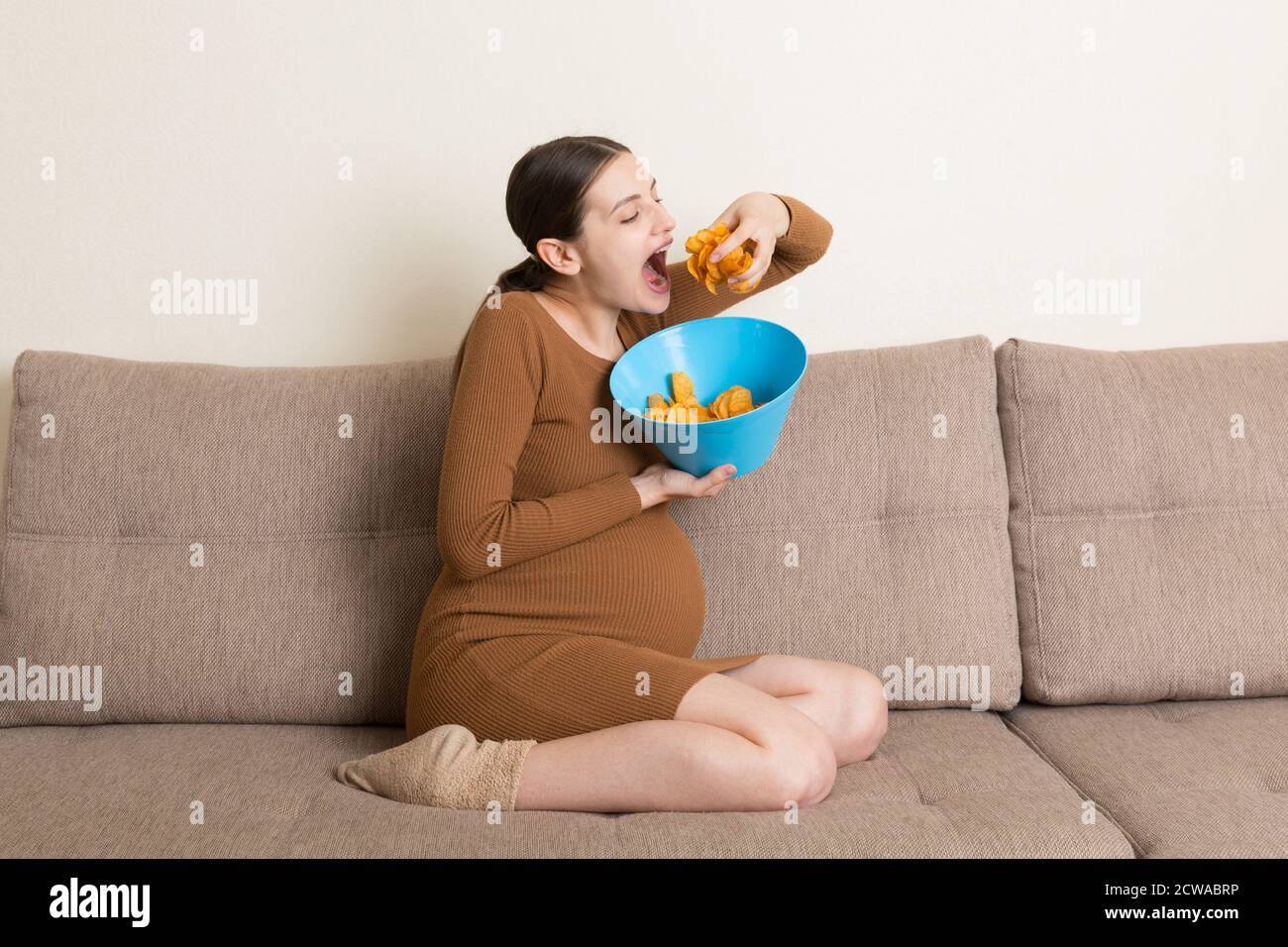 Pregnant woman is eating potato chips because of salt cravings