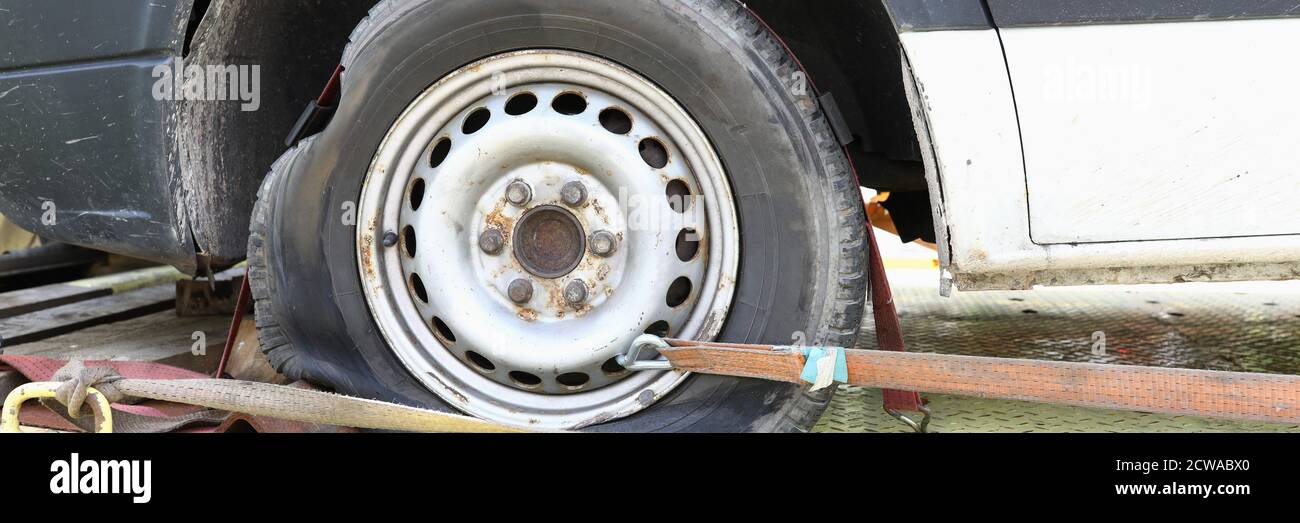 Car is on tow truck with flat tire closeup Stock Photo