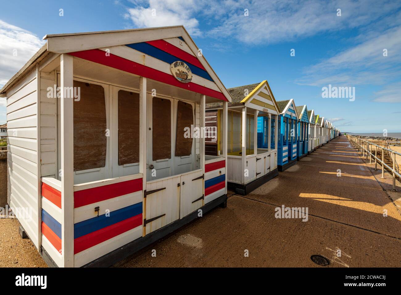 A row of colourful beach huts on the seafront at Southwold on a summers day on the Suffolk Coast. Stock Photo