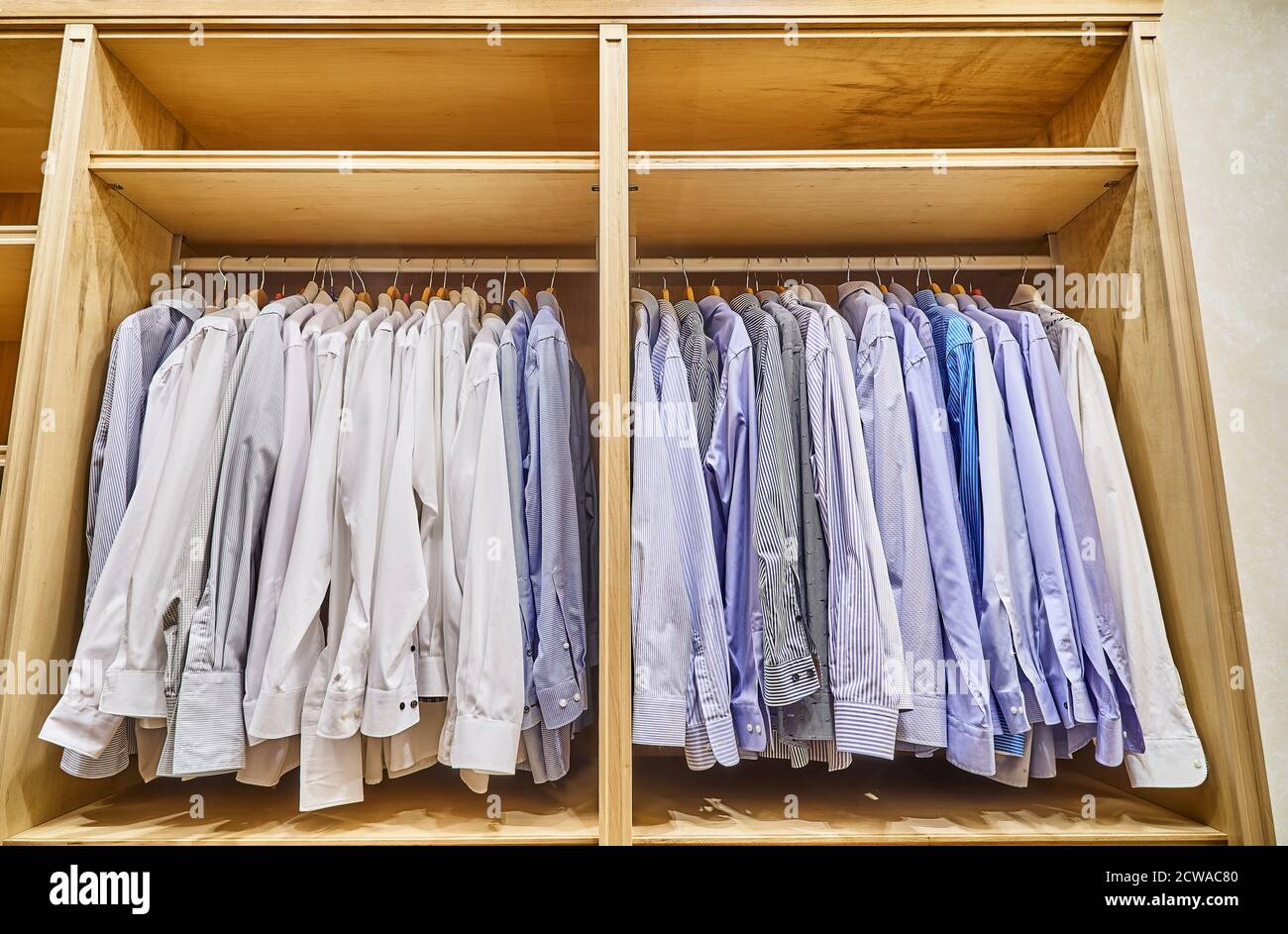 Men's shirts are hanging in the wooden closet dressing room. Wooden  wardrobe Stock Photo - Alamy
