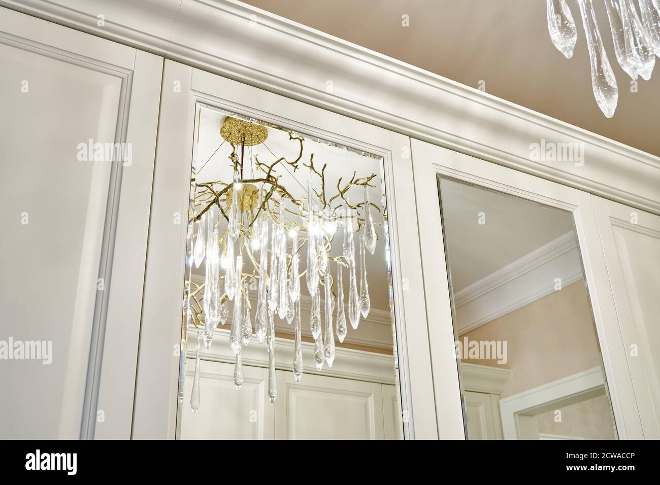 Classic white wardrobe with mirror doors in contemporary bright hallway