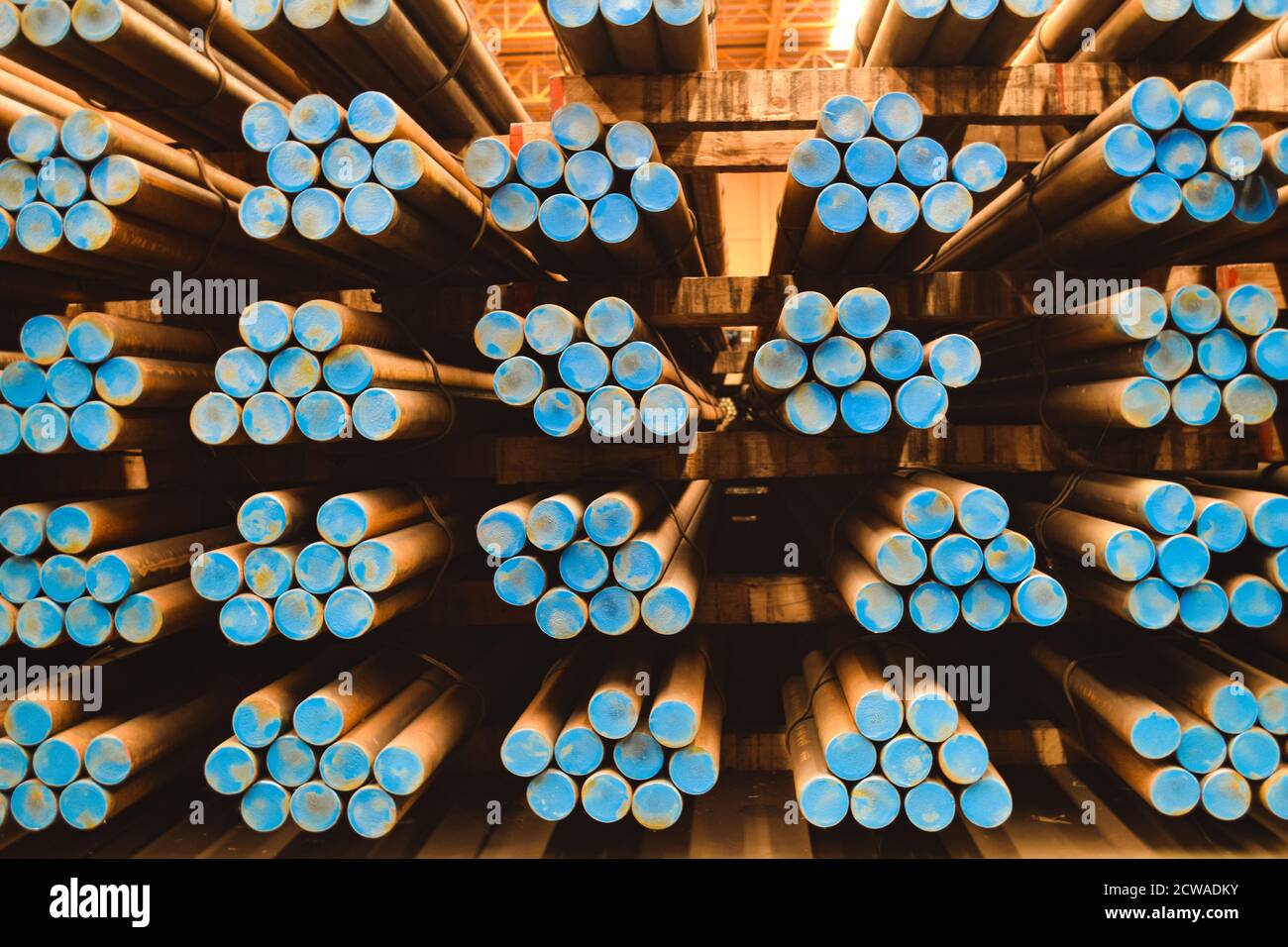 Pack of steel round bar stack in layer inside large distribution warehouse. Steel warehouse logistics operations. Stock Photo