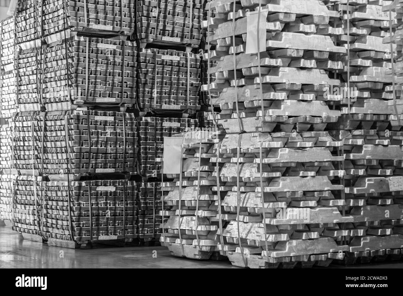 Aluminum ingot bar stacked in warehouse. Raw material for industrial concept. General cargo warehouse concept Stock Photo