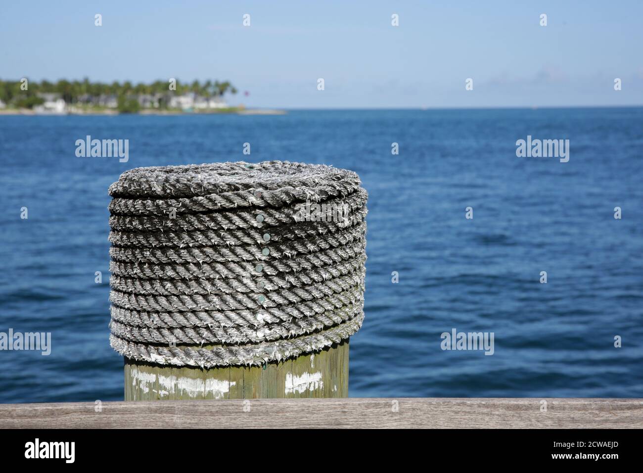 Weathered rope coated bollard for securing boats on a wharf at Key West, Florida, USA Stock Photo