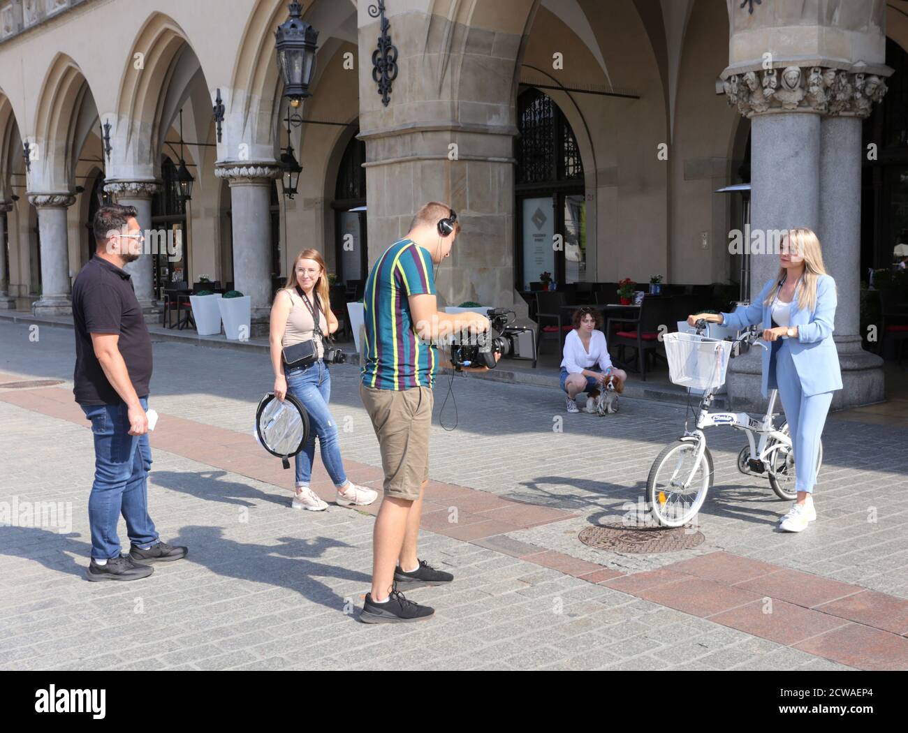 Cracow, Malopolska/Poland - 16.09.2020:  TV camera crew shooting advert film scene with handheld camera in front of Cloth Hall (Sukiennnice). Stock Photo