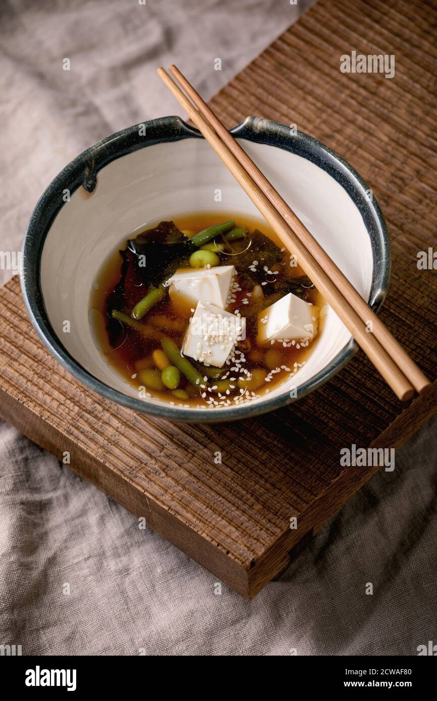 Japanese Miso broth soup with silk tofu cubes, soy beans edamame, green
