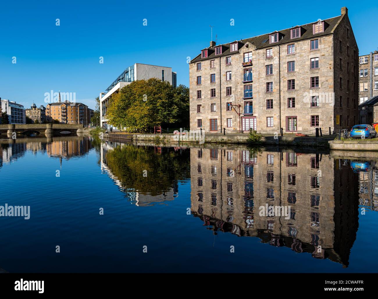 Leith, Edinburgh, Scotland, United Kingdom, 29th September 2020. UK Weather: sunshine on Leith. The sun really does shine on the Water of Leith and on a calm sunny day creates wonderful reflections in the water around The Shore with The Cooperage, a bond warehouse converted into riverside flats, reflected in the calm Water of Leith river Stock Photo