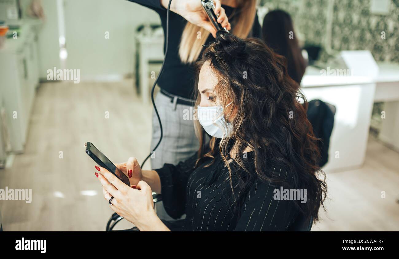 Woman in medical mask gets her hair done in beauty salon during pandemic Stock Photo Alamy