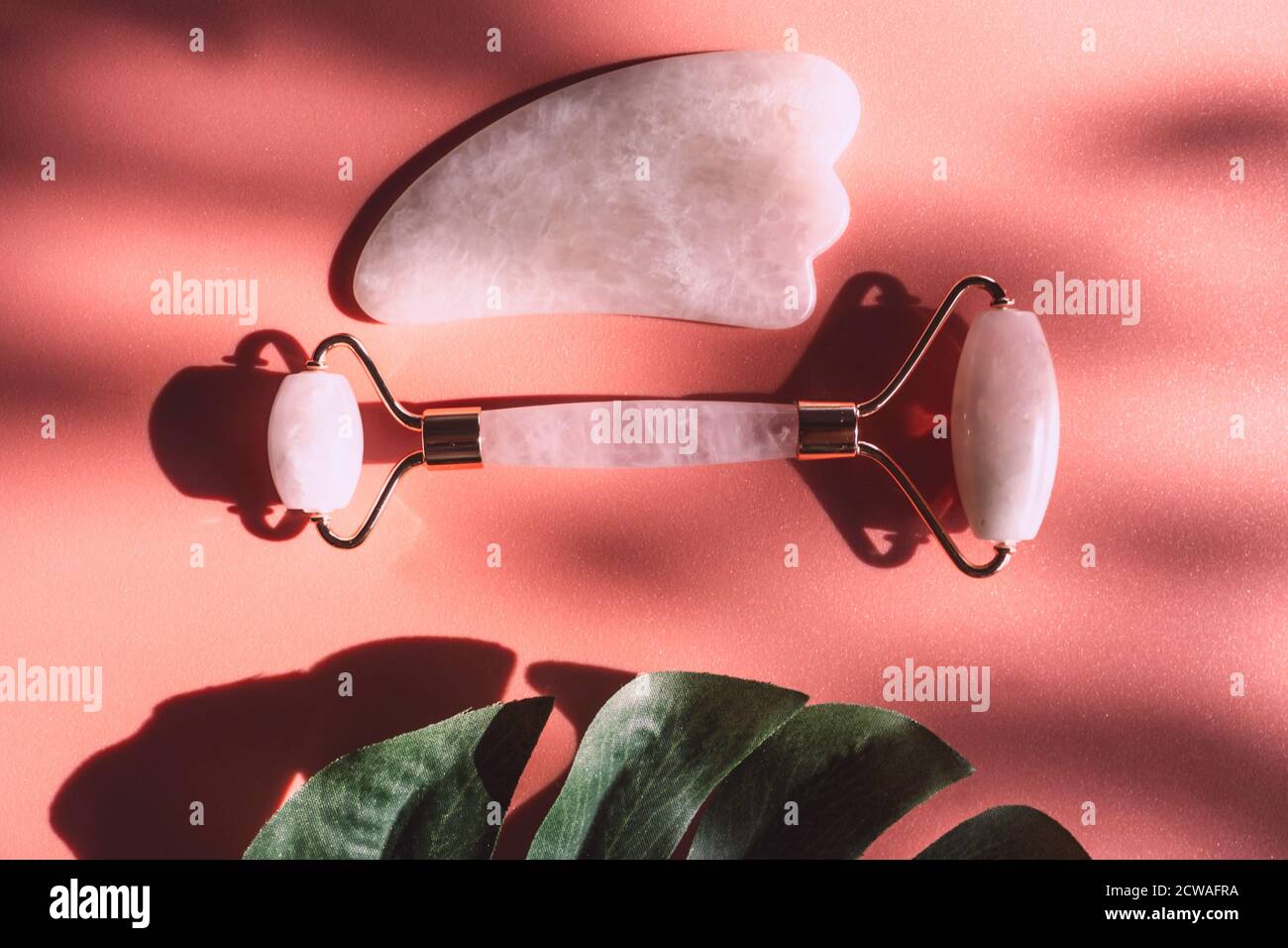 Facial jade massage derma roller or gua sha with trendy shadows, beauty