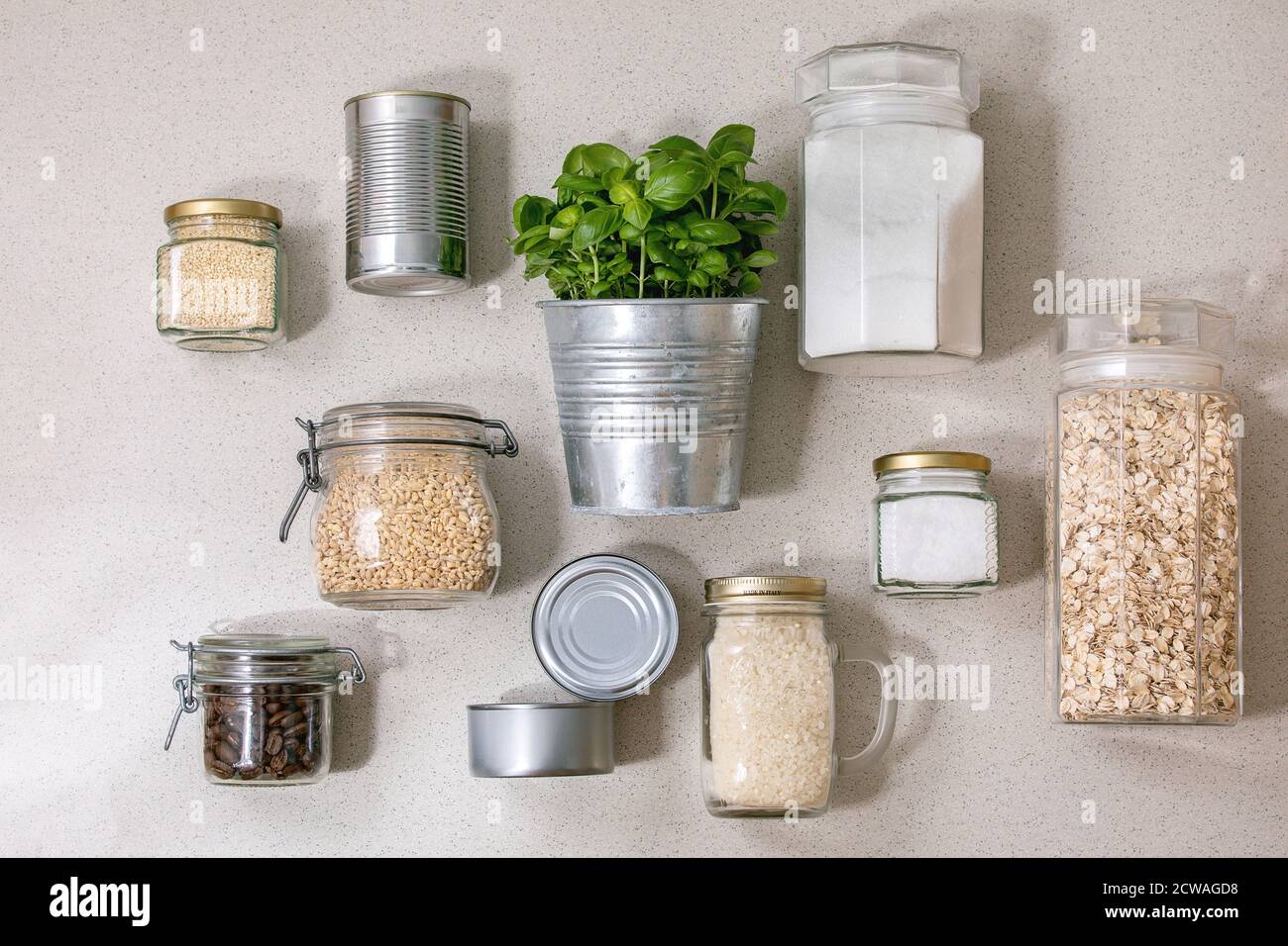 Flat lay of food supplies crisis for quarantine isolation period. Different glass jars with grains, cans of canned food, pot of basil Stock Photo