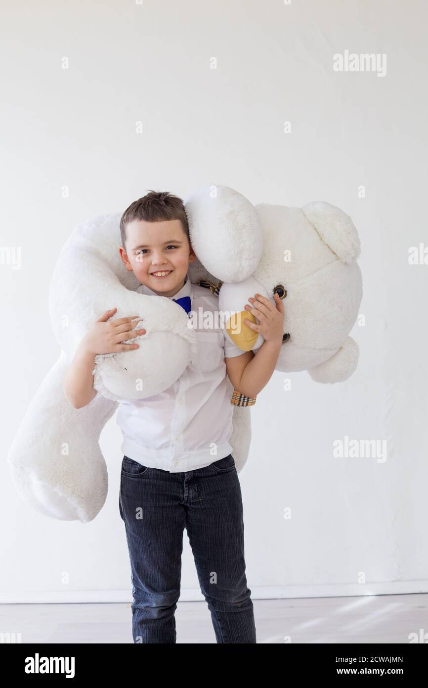 Beautiful little boy holding a white teddy bear toy Stock Photo - Alamy
