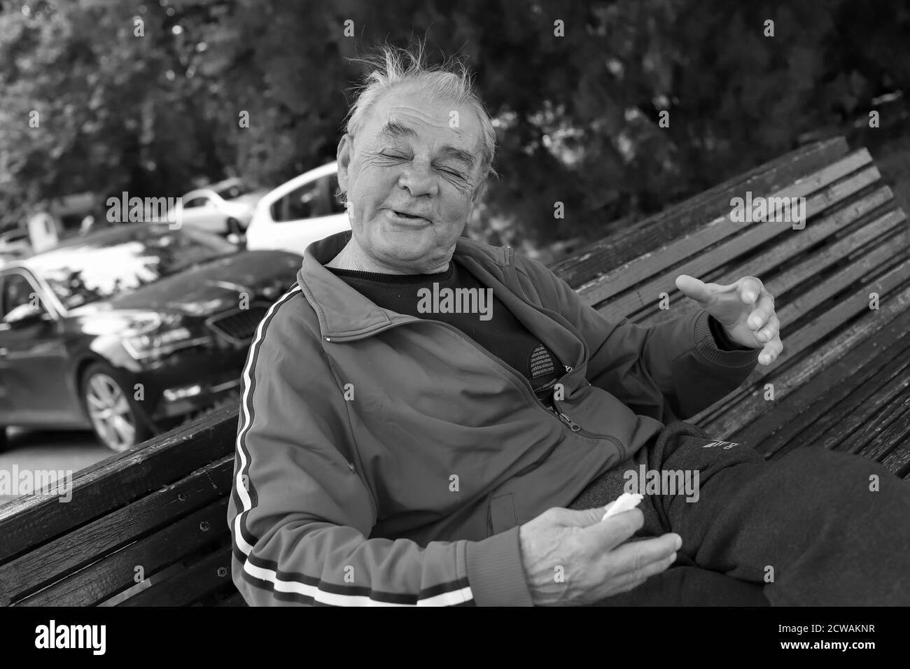 Belgrade, Serbia, Jun 18, 2020: Portrait of a drunk man sitting on a bench (B/W) Stock Photo