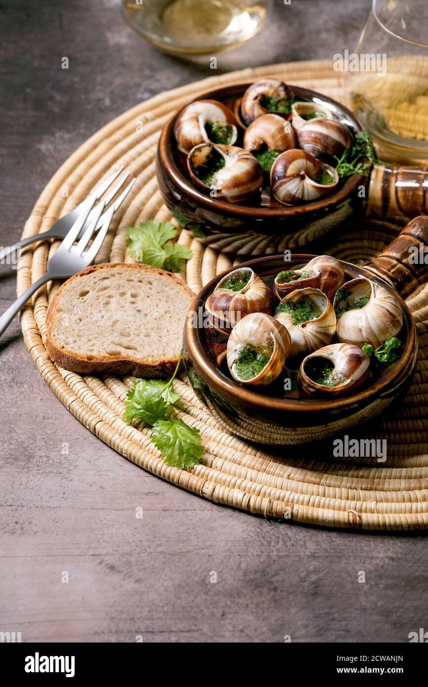 Escargots De Bourgogne Snails With Herbs Butter Gourmet Dish In Two Traditional Ceramic Pans With Coriander Bread And Glass Of White Wine On Stra Stock Photo Alamy
