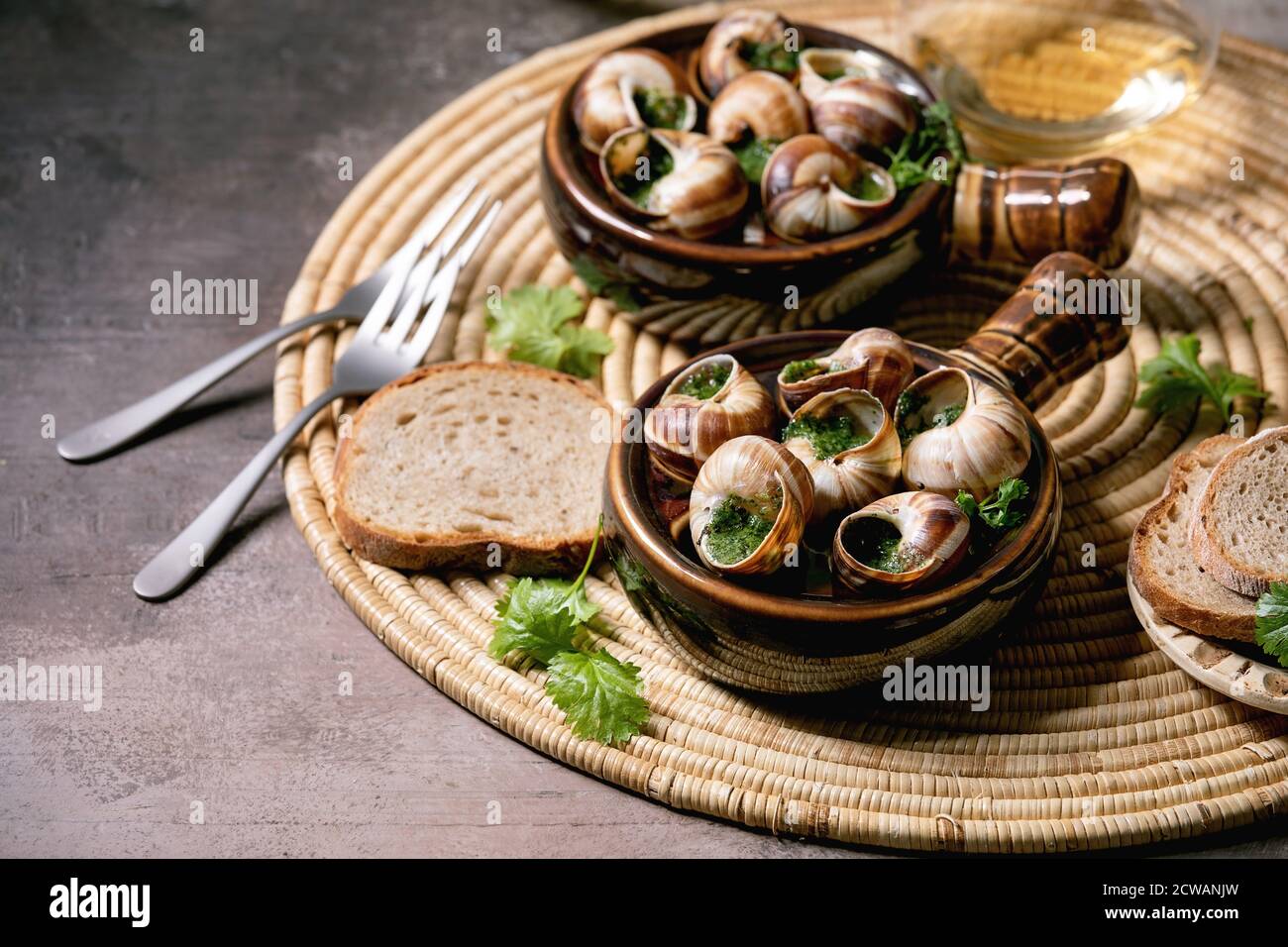Escargots De Bourgogne Snails With Herbs Butter Gourmet Dish In Two Traditional Ceramic Pans With Coriander Bread And Glass Of White Wine On Stra Stock Photo Alamy