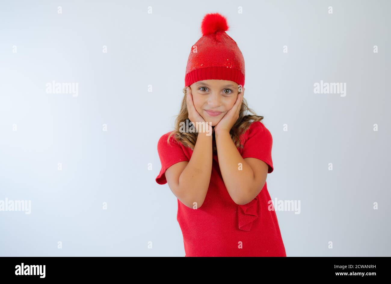 portrait of happy charming little girl wearing knitted red hat and cute ...