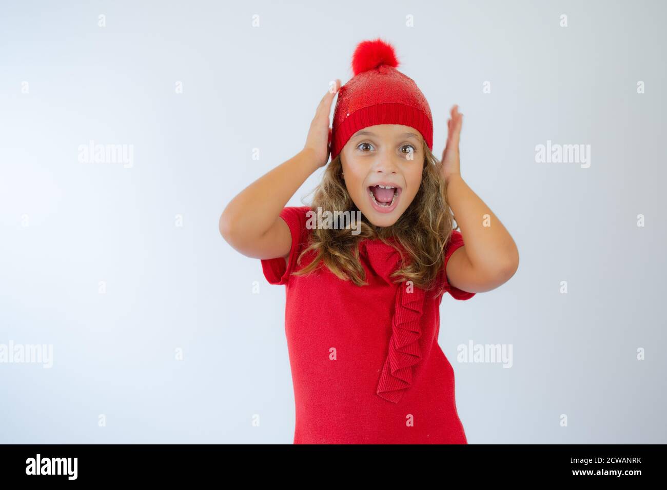 portrait of happy charming little girl wearing knitted red hat and cute ...