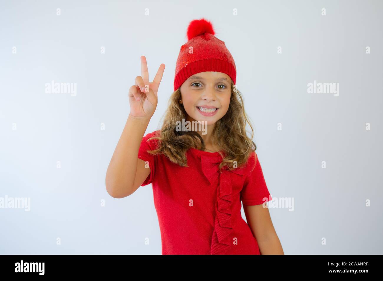 portrait of happy charming little girl wearing knitted red hat and cute ...