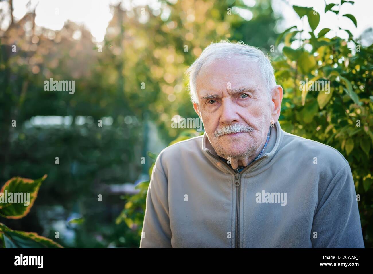 Artistic portrait of a friendly older old man on the street close-up. Copy space Stock Photo