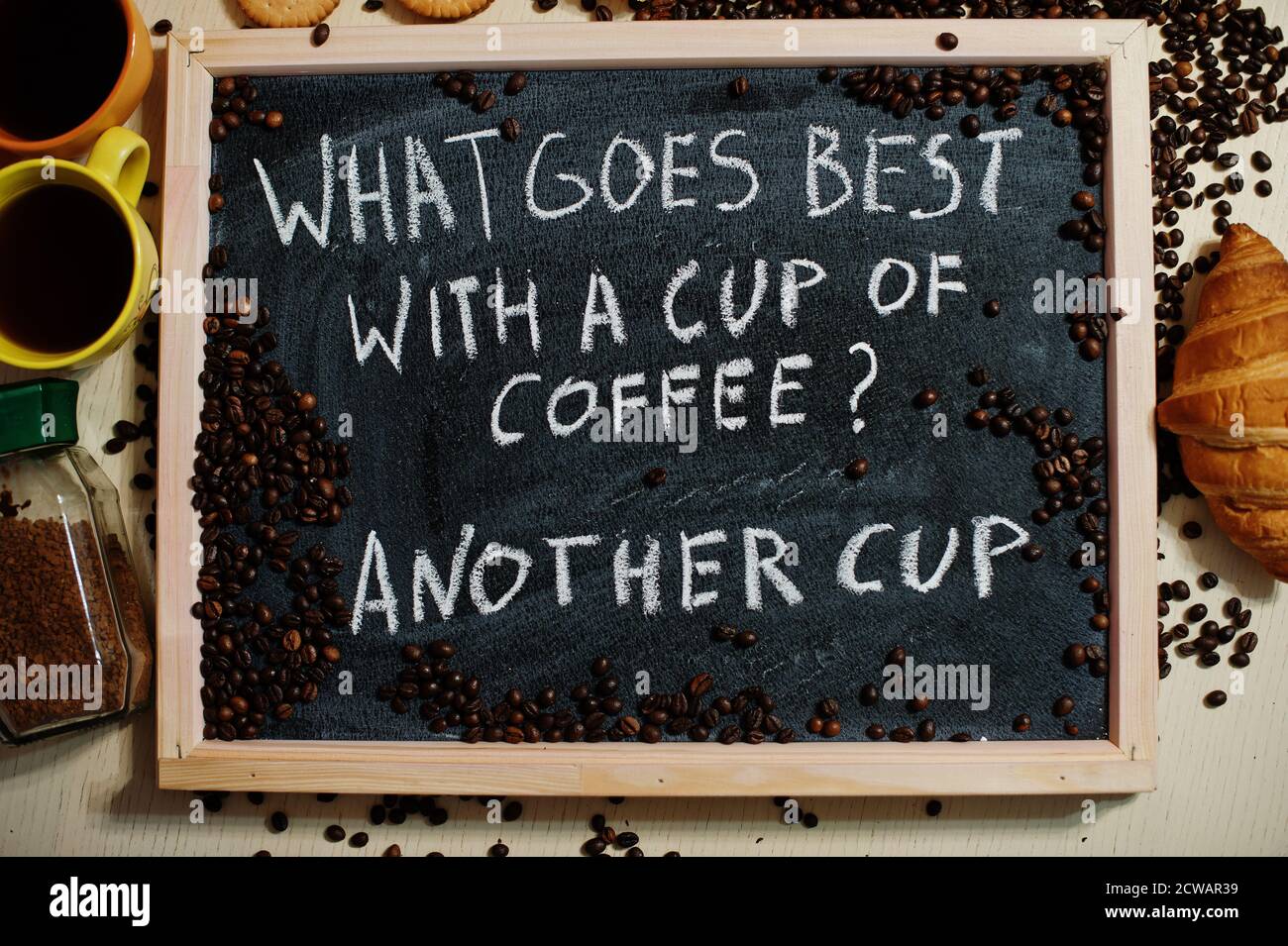 What goes best with a cup of coffee? Another cup. Words on blackboard flat  lay Stock Photo - Alamy