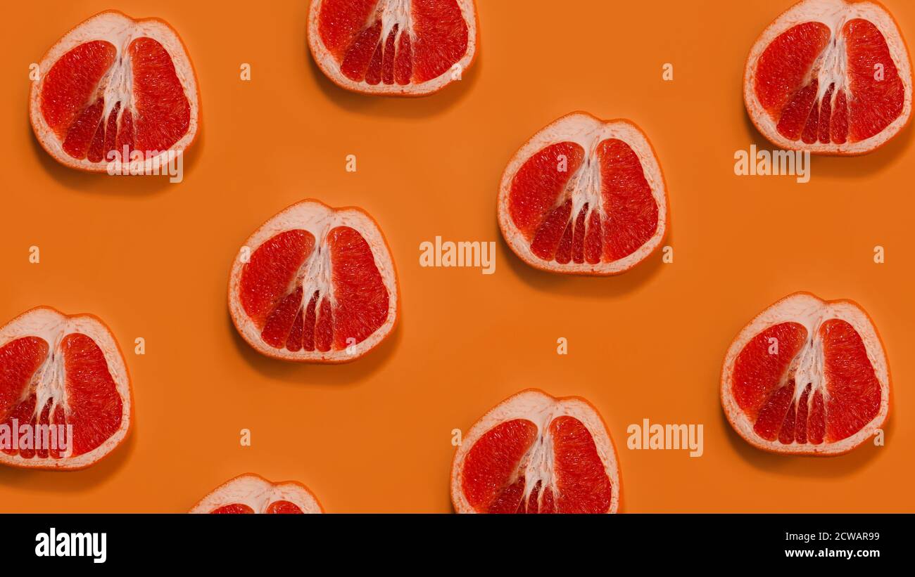 Grapefruit pattern on orange background. Minimal flat lay concept. Stock Photo