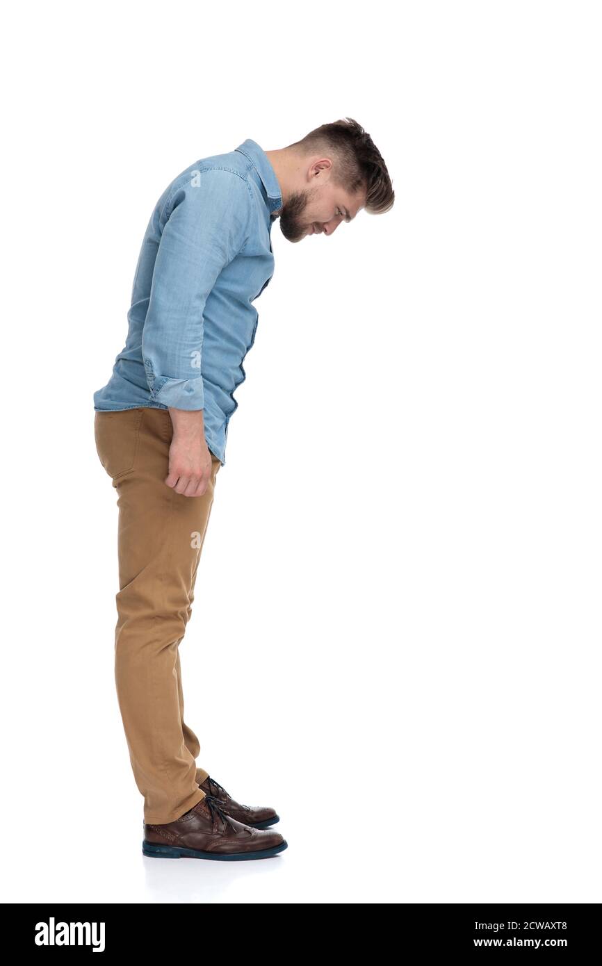 Side view of a eager casual man curiously looking down, standing
