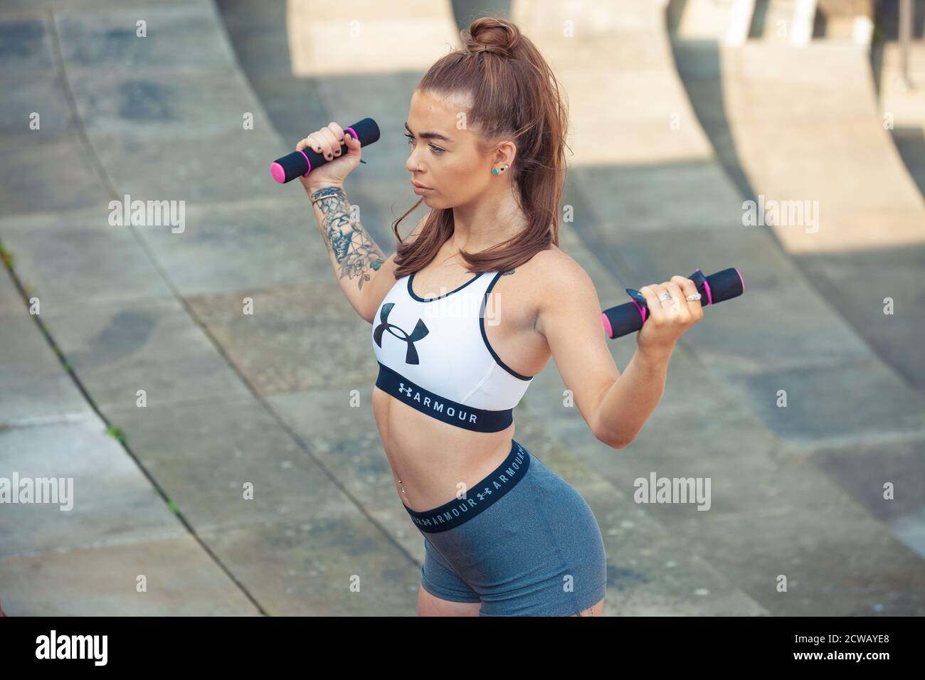 Woman exercising outdoors with hand weights Stock Photo