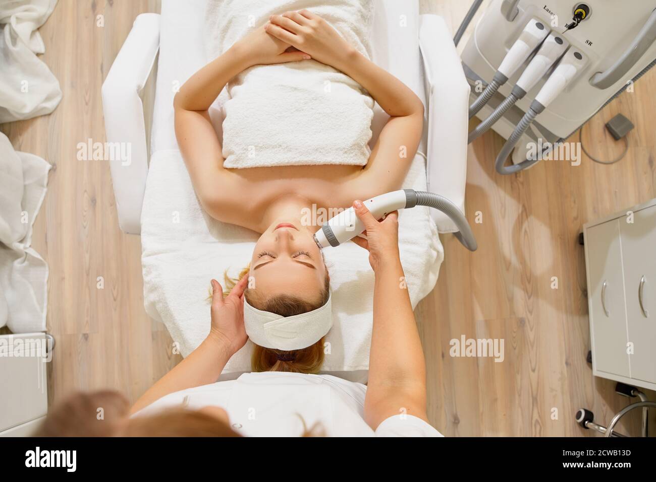 woman close up receiving electric facial massage on microdermabrasion equipment at beauty salon. Stock Photo