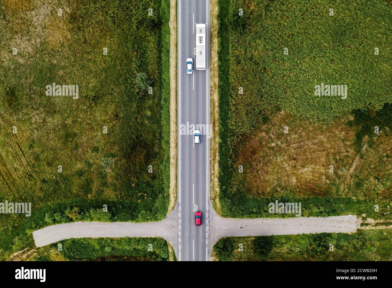 Aerial view of three cars and passenger bus on the road, top view from drone pov Stock Photo