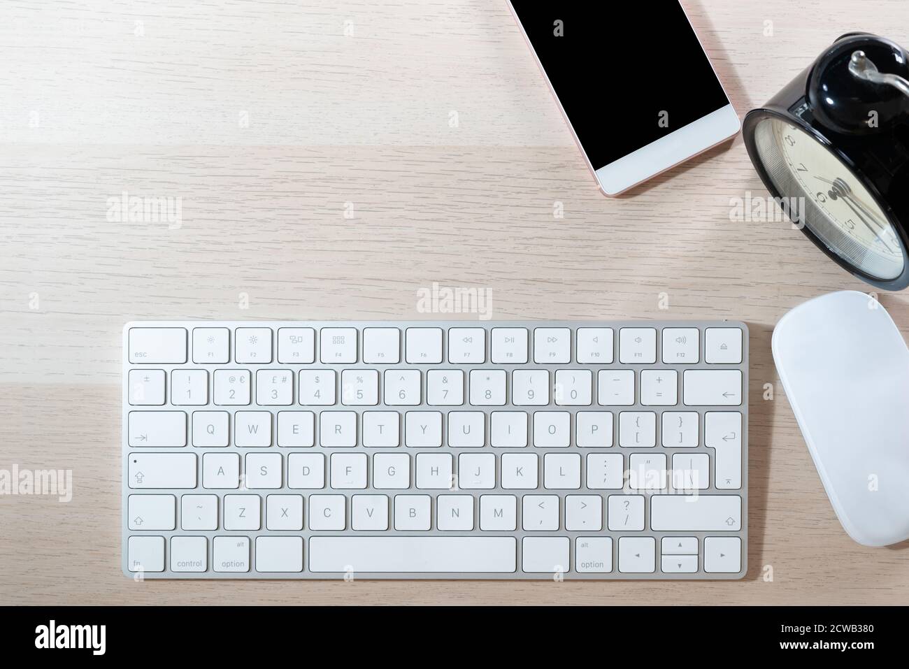 office table with computer keyboard, mouse, smartphone and alarm clock. topview, copy space Stock Photo