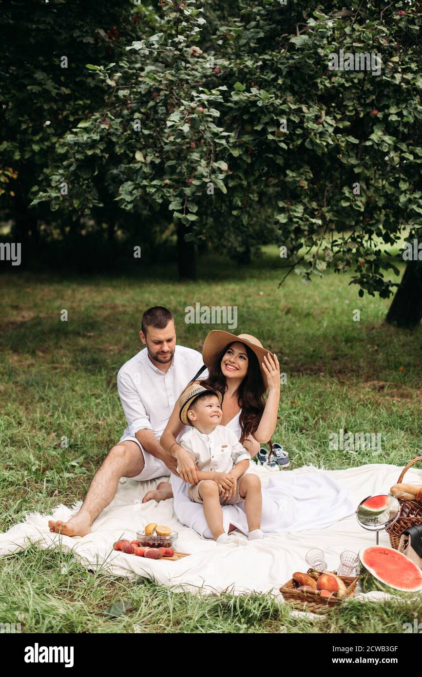 Beautiful mum, dad and their cute little child have fun together and ...