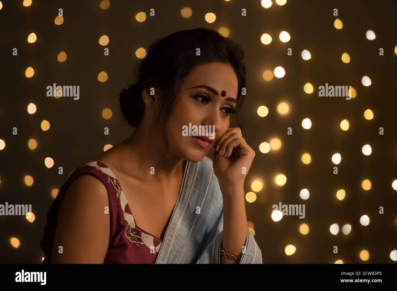 Beautiful woman in saree lost in thought Stock Photo